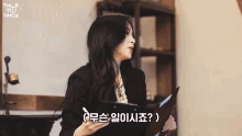 a woman in a suit holds a clipboard and says " twice " in a foreign language
