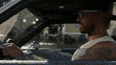 a man wearing sunglasses and a hat is sitting in a car