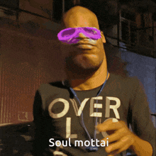 a man wearing sunglasses and a shirt that says over soul mottai