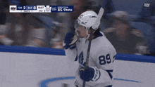 a hockey player with the number 89 on his jersey stands on the ice