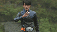 a young man in a blue and black jacket is holding a white object in his hand