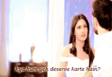 a man and a woman are looking at each other and the woman says kya hum yeh deserve karte hain .
