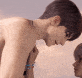 a man without a shirt is touching a woman 's arm