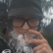 a man wearing glasses is smoking a cigarette