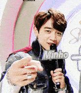 a young man is holding a sign that says minho in front of a microphone
