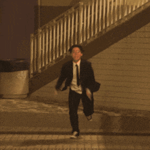 a man in a suit and tie is running down a street