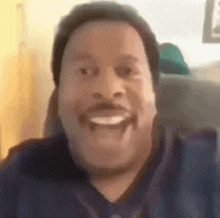 a man with a mustache is smiling and making a funny face in a blurry photo .