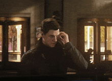 a man in a black jacket talking on a cell phone with the word kepler on the bottom right