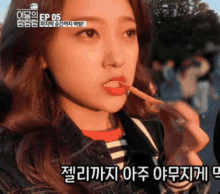 a girl is eating a stick with korean writing on it