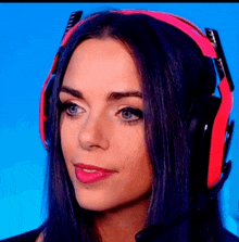 a woman with purple hair is wearing a pair of red headphones with a microphone .