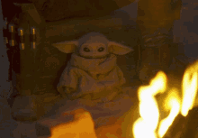 a stuffed animal is sitting in the snow next to a fire