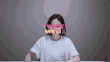 a woman sitting at a table with twice mbti written in pink behind her
