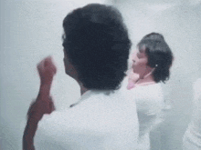 a man and a woman are standing in a bathroom .