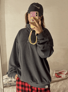 a woman taking a picture of herself in a mirror with her phone