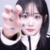 a close up of a girl 's face and hand