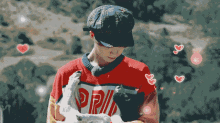 a pixelated image of a man holding a cat with the letter r on the shirt