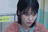 a close up of a woman 's face with a sign in the background that says ' a ' on it