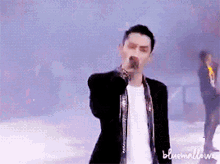 a man singing into a microphone with bluemallows written on the bottom right