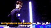 a man is standing in front of a light saber with the words `` just gestures and grunts '' written above him .