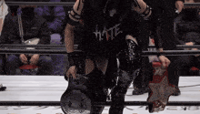a wrestler wearing a black shirt that says hate