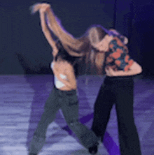 a blurry picture of two women dancing on a stage