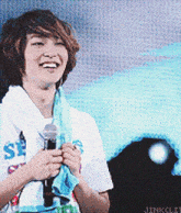 a young man holding a microphone with a shirt that says se on it