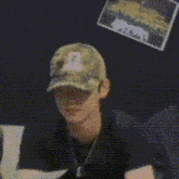 a man in a black shirt and necklace is being touched by a person .