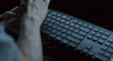 a person is typing on a keyboard with a mouse pointer pointing to the shift key