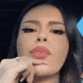 a close up of a woman making a funny face with her finger in her mouth .