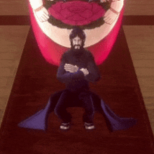 a man with a beard is standing on a red carpet with his arms crossed in front of a large red object .