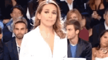 a woman in a white shirt is standing in front of a crowd .