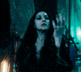 a woman with a scar on her face holds her hand up in the air