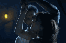 a man and a woman kissing in a dark room