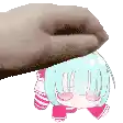 a hand is putting a stuffed animal on top of a small girl .