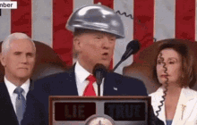 donald trump is wearing a hard hat while giving a speech .