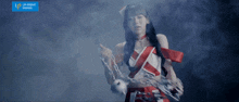 a girl in a red and white dress is holding chains in front of a sign that says up front works