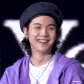 a close up of a person wearing a hat and a purple jacket