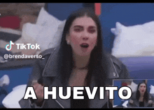 a woman in a black jacket says a huevito on a tiktok video