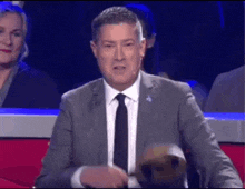 a man in a suit and tie is giving a speech