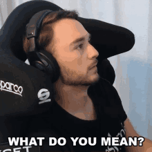 a man wearing headphones is sitting in a parco chair asking what do you mean