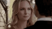 a man and a woman are looking at each other . the woman is wearing a headband .