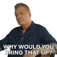 a man wearing a denim shirt is asking why would you bring that up