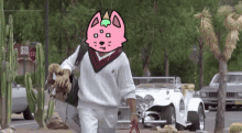 a man with a pink cat on his head walking down a street