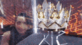a woman is smiling in front of a crown