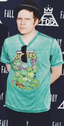 a man wearing a turtles t-shirt and a hat