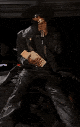 a man in a leather jacket is holding a stack of money in his hands