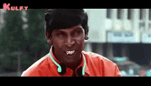 a man wearing a red shirt and headphones is smiling .