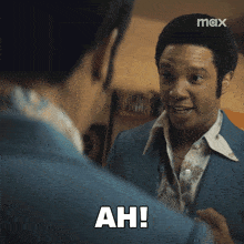a man in a blue suit is talking to another man and says ah