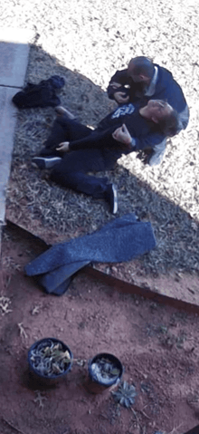 a man in a gap shirt is laying on the ground with another man