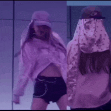 a woman in a pink shirt and black shorts is dancing on a stage .